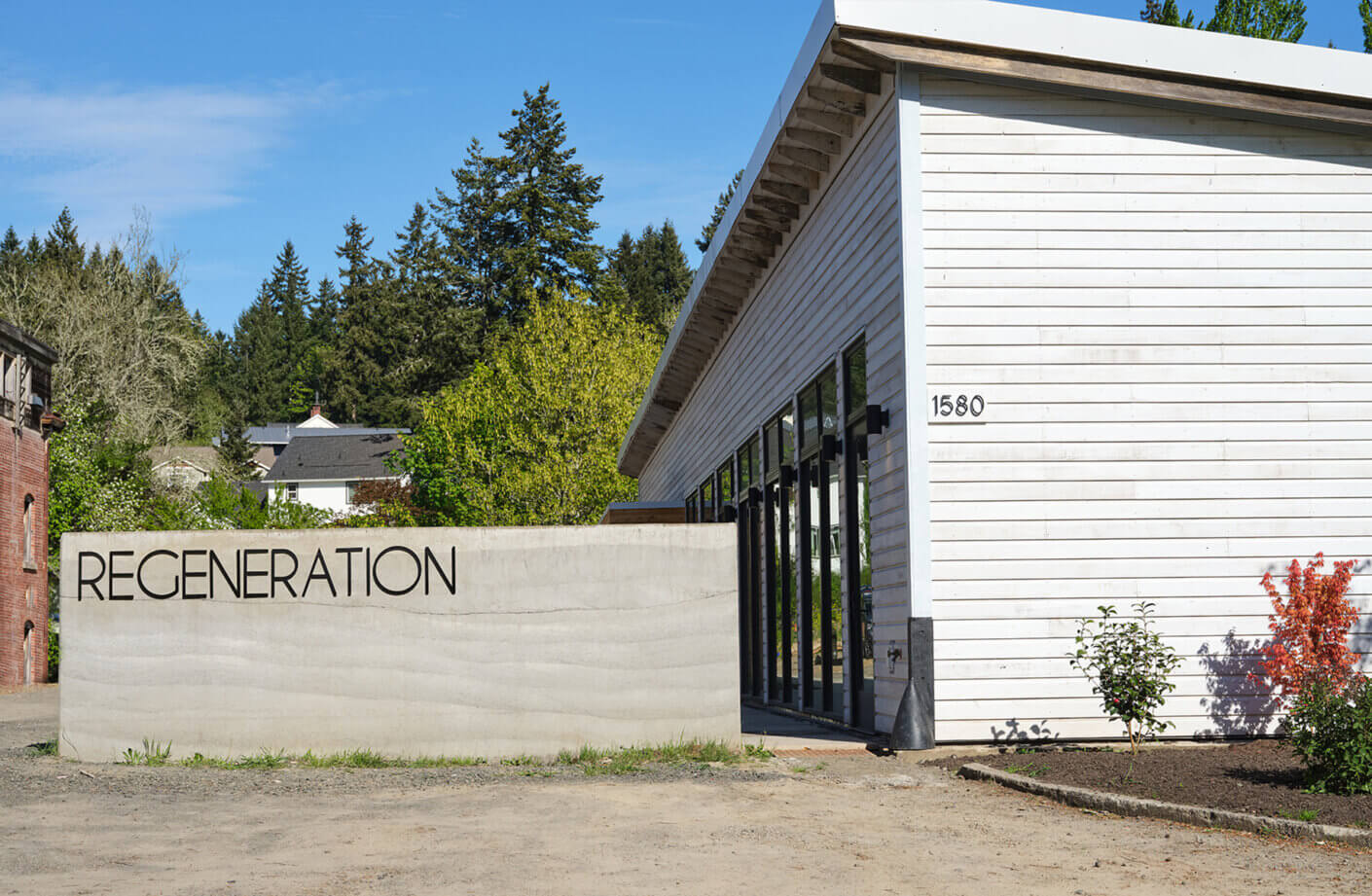exterior of the studio, with a rammed earth signed that says